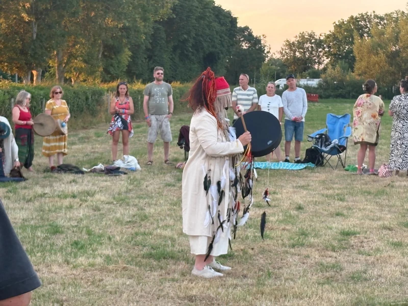 Campers gathering in the field for a drum circle